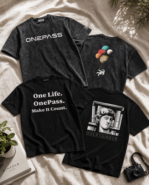 Four black t-shirts with different designs on a light fabric background.